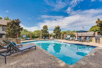 Resort style pool with lounge chairs and grill area
